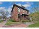 Charming two-story brick home with a well-maintained lawn and inviting front porch on a sunny day at 2560 Champa St, Denver, CO 80205