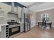 Modern kitchen featuring stainless steel appliances, dark blue accent wall and a dining area with a chandelier at 2560 Champa St, Denver, CO 80205