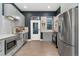 Modern kitchen featuring stainless steel appliances, gray cabinetry, and chic white backsplash at 2560 Champa St, Denver, CO 80205
