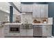 This kitchen showcases stainless steel appliances, light grey cabinets with gold accents and mosaic backsplash at 2560 Champa St, Denver, CO 80205