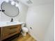 Stylish bathroom with modern vanity, round mirror, and new toilet at 4623 S Lowell Blvd, Denver, CO 80236