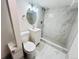 Updated bathroom featuring marble tiled shower and white vanity with gold mirror at 4623 S Lowell Blvd, Denver, CO 80236