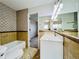 Bathroom featuring new vanity, mirror, and tub with shower head at 4623 S Lowell Blvd, Denver, CO 80236