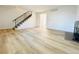 Large living room shows wood-look flooring, stairs and a brick fireplace at 4623 S Lowell Blvd, Denver, CO 80236