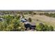 An aerial view of a black home surrounded by green trees and open land at 6275 Ponderosa Way, Parker, CO 80134