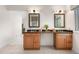 Bright bathroom featuring tile flooring, wooden cabinets, granite countertop, double sinks and windows at 6275 Ponderosa Way, Parker, CO 80134