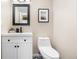 This bathroom features a black framed mirror, a toilet, and a modern sink at 6275 Ponderosa Way, Parker, CO 80134