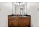 Bathroom featuring tile flooring, wooden cabinets, granite countertop, double sinks, vanity lighting and mirror at 6275 Ponderosa Way, Parker, CO 80134