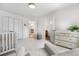 Bright bedroom featuring a crib, changing table, and views to an ensuite bath and other rooms at 6275 Ponderosa Way, Parker, CO 80134