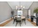 Open-concept dining room with hardwood floors, modern lighting, and a view to the living area at 6275 Ponderosa Way, Parker, CO 80134