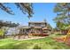Exterior view of a charming home with a lush green lawn, mature trees, and a backyard playset at 6275 Ponderosa Way, Parker, CO 80134