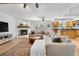 Spacious living area with a brick fireplace, bay windows, and an open layout to the adjacent kitchen at 6275 Ponderosa Way, Parker, CO 80134