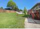 Spacious backyard with a well-maintained lawn, a wooden fence, and a red deck at 6869 Quay St, Arvada, CO 80003