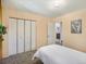Bedroom with neutral walls and carpet, double closet, white bedding, and door to other rooms at 6869 Quay St, Arvada, CO 80003