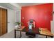 Office with red accent wall, modern desk and chair, light gray carpet and white trim at 6869 Quay St, Arvada, CO 80003
