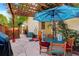 Cozy outdoor patio with a wooden pergola, stone pavers, and table with colorful patio umbrella at 1620 Oak Ave, Boulder, CO 80304