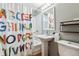 Charming bathroom with an 'ABC' shower curtain, pedestal sink, and modern fixtures at 1640 Quince St, Denver, CO 80220