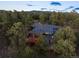 Aerial view of home surrounded by trees and the natural landscape of the surrounding area at dusk at 28890 Pinewood Vista Dr, Evergreen, CO 80439