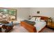 Comfortable bedroom with a wooden bed frame and large window offering natural light at 28890 Pinewood Vista Dr, Evergreen, CO 80439
