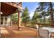 Outdoor deck area with wood flooring, a railing, a table, and great views of the surrounding trees and property at 28890 Pinewood Vista Dr, Evergreen, CO 80439