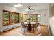 Sunlit dining room features hardwood floors, a modern ceiling fan, and large windows overlooking the trees at 28890 Pinewood Vista Dr, Evergreen, CO 80439