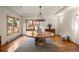 Elegant dining room featuring a custom wood table, unique lighting, and views of the landscaped outdoor space at 28890 Pinewood Vista Dr, Evergreen, CO 80439