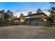Spacious three-car garage with a large driveway, complemented by solar panels on the roof at 28890 Pinewood Vista Dr, Evergreen, CO 80439