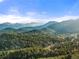 Scenic mountain range under blue sky with lush forest landscape in the foreground and surrounding mountains at 28890 Pinewood Vista Dr, Evergreen, CO 80439