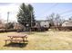 Large backyard with green grass, mature trees, a playset, and a picnic table at 5200 W Ottawa Ave, Littleton, CO 80128