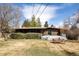 Expansive backyard featuring a spacious deck, a picnic table, and lush landscaping at 5200 W Ottawa Ave, Littleton, CO 80128