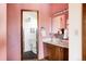 Pink bathroom with wood vanity and black tile floor at 5200 W Ottawa Ave, Littleton, CO 80128