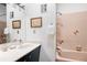 Retro bathroom featuring pink tile, a vanity with a modern sink, and framed wall art at 5200 W Ottawa Ave, Littleton, CO 80128