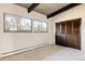 Bright bedroom featuring exposed beam ceiling, two large windows, and spacious closet at 5200 W Ottawa Ave, Littleton, CO 80128