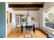 Bright dining room with hardwood floors, wood beam ceiling, and modern chandelier lighting at 5200 W Ottawa Ave, Littleton, CO 80128