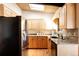 Bright kitchen with light wood cabinets, granite counters, and stainless-steel refrigerator and fixtures at 5200 W Ottawa Ave, Littleton, CO 80128