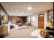 Cozy living room with a brick fireplace, wood-paneled wall, and large windows at 5200 W Ottawa Ave, Littleton, CO 80128