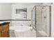 Soaking tub and shower featuring marble tiling and bright lighting in the bathroom at 40 Madison St # 203, Denver, CO 80206