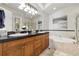 Elegant bathroom with double vanity, soaking tub, and a separate glass enclosed shower at 40 Madison St # 203, Denver, CO 80206