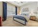 Bedroom featuring a bed with white headboard, bedside tables and bright window with curtains at 40 Madison St # 203, Denver, CO 80206