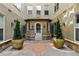 Inviting condo entrance with elegant potted trees and an arched doorway at 40 Madison St # 203, Denver, CO 80206