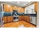 Well-lit kitchen featuring wood cabinets, stainless steel appliances, and dark countertops at 40 Madison St # 203, Denver, CO 80206