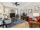 Cozy living room features a fireplace, neutral walls and furniture, and an ornate ceiling fan at 40 Madison St # 203, Denver, CO 80206