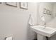 Elegant half bathroom with a pedestal sink, decorative mirror, and contemporary design at 1284 Quitman St, Denver, CO 80204