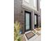 Modern townhome entryway with a dark-bricked exterior and black front door at 1284 Quitman St, Denver, CO 80204