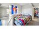 Cozy bedroom with bright Colorado flag, colorful quilt and a view to the stairwell at 5415 W 16Th Ave, Lakewood, CO 80214
