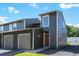 Modern townhome featuring gray siding, an attached garage, and a well-maintained lawn on a sunny day at 5415 W 16Th Ave, Lakewood, CO 80214