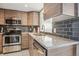 Modern kitchen featuring stainless steel appliances, gray backsplash, and light wood cabinetry, creating a stylish cooking space at 5415 W 16Th Ave, Lakewood, CO 80214