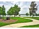 Serpentine sidewalks wind through a green park with a lake and mountain views at 5415 W 16Th Ave, Lakewood, CO 80214