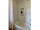 Bathroom featuring white subway tile with a built-in niche and shower with white curtain at 8503 E Jamison Ave, Centennial, CO 80112