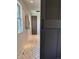 A narrow bathroom showcasing herringbone-patterned tile flooring, a gray door, and white shiplap walls at 8503 E Jamison Ave, Centennial, CO 80112